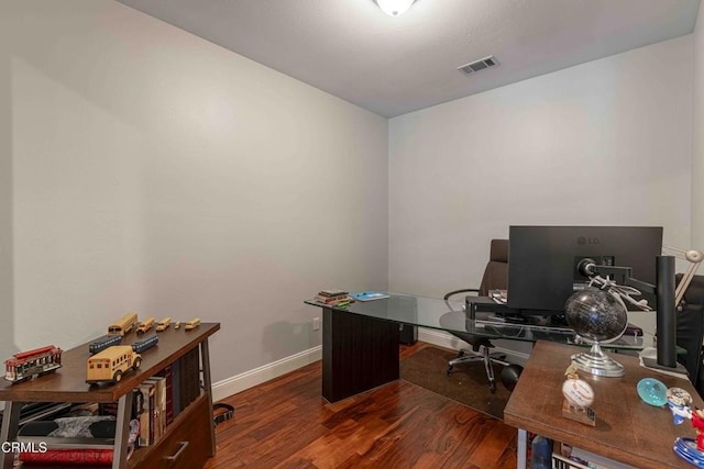 home office featuring visible vents, baseboards, and wood finished floors