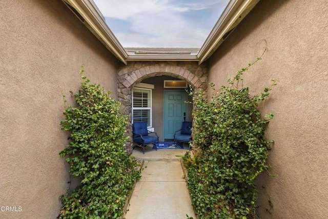 view of exterior entry with stone siding and stucco siding