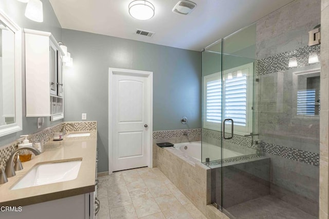 bathroom with visible vents, a garden tub, a sink, a shower stall, and double vanity