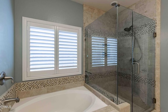 bathroom featuring a bath and a shower stall