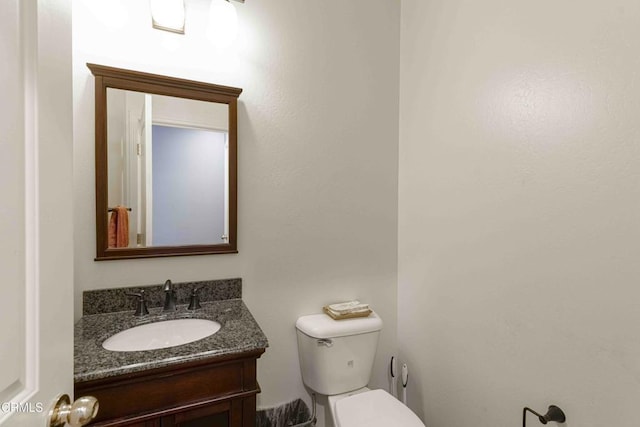 half bath featuring toilet and vanity