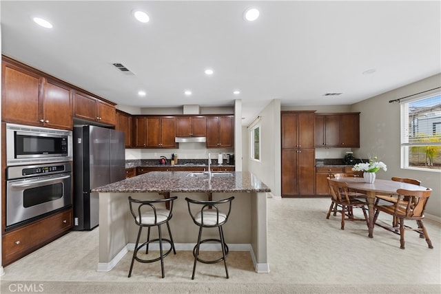 kitchen featuring visible vents, recessed lighting, stainless steel appliances, and a kitchen bar