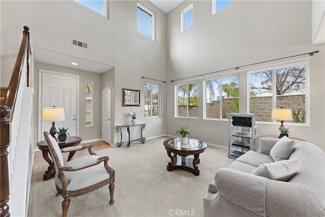 carpeted living room featuring stairs, baseboards, and visible vents