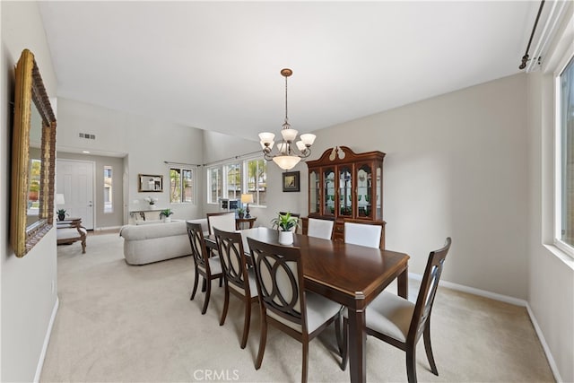 dining room featuring light carpet, visible vents, baseboards, and an inviting chandelier