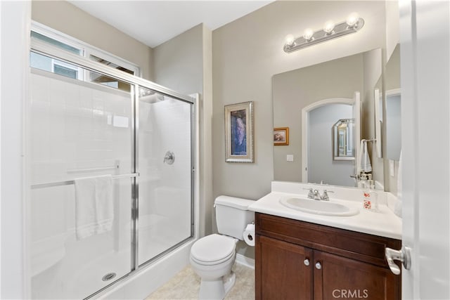 full bathroom featuring vanity, toilet, and a shower stall