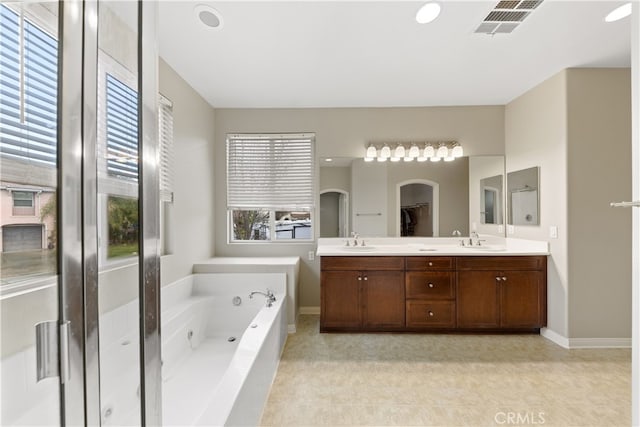 bathroom with a sink, visible vents, a bath, and double vanity