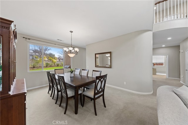 dining room featuring light carpet, visible vents, a chandelier, and baseboards