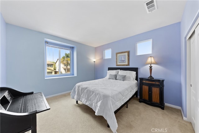 bedroom with visible vents, light carpet, baseboards, and a closet