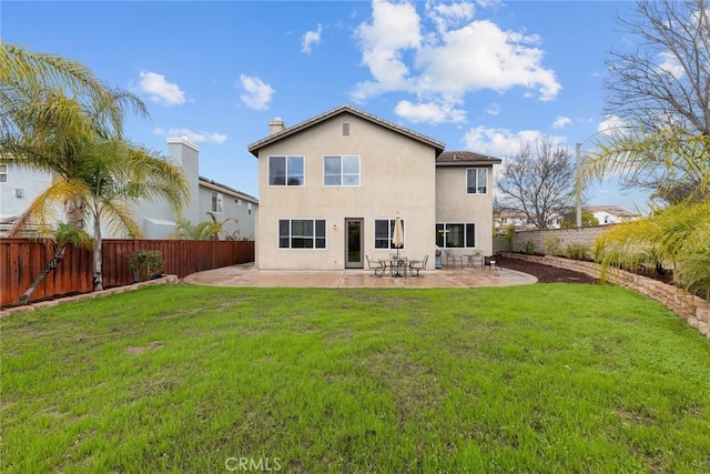 back of house featuring stucco siding, a patio, a lawn, and a fenced backyard