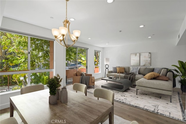 dining space with a chandelier, recessed lighting, and wood finished floors