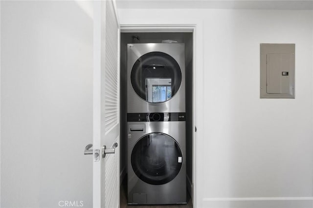 clothes washing area with laundry area, electric panel, and stacked washer / drying machine