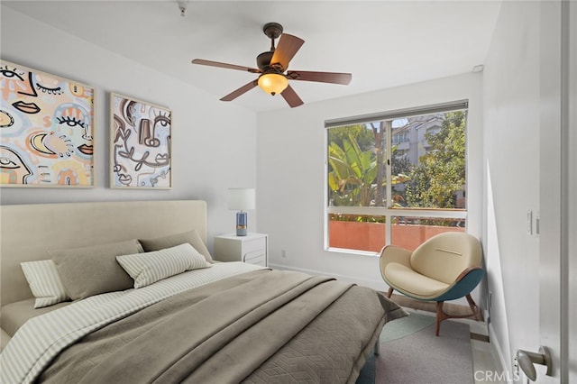 carpeted bedroom with ceiling fan and baseboards