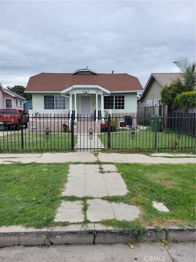 bungalow-style house featuring a fenced front yard, stucco siding, a front yard, and a gate