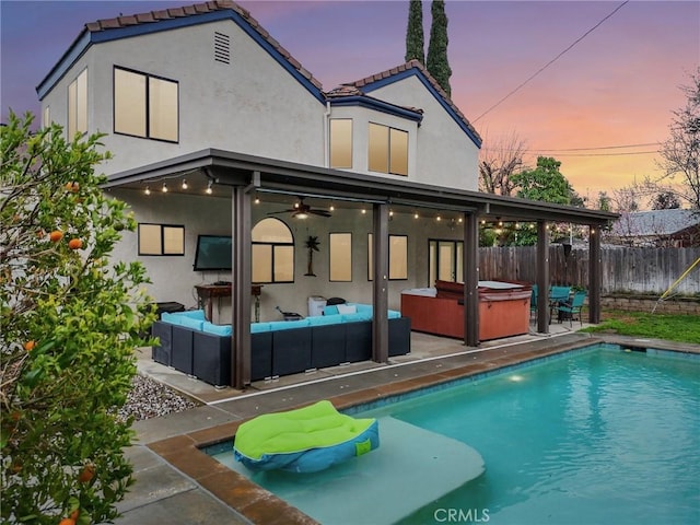 view of pool with an outdoor living space, a fenced in pool, a hot tub, fence, and a patio area