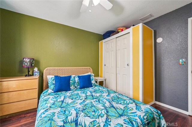 bedroom featuring visible vents, baseboards, a closet, and dark wood finished floors