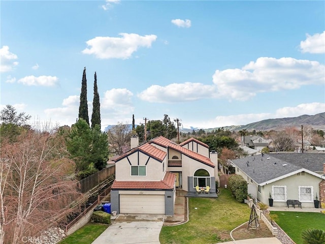 view of front facade with fence, concrete driveway, a front yard, a chimney, and a garage