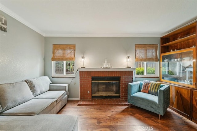 living room with baseboards, a brick fireplace, wood finished floors, and ornamental molding