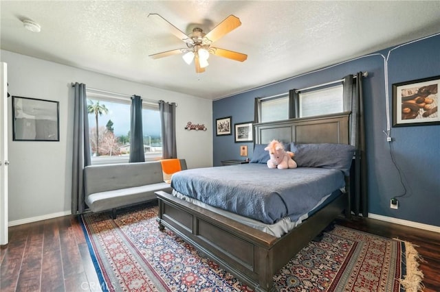 bedroom featuring baseboards, dark wood-style flooring, and a textured ceiling