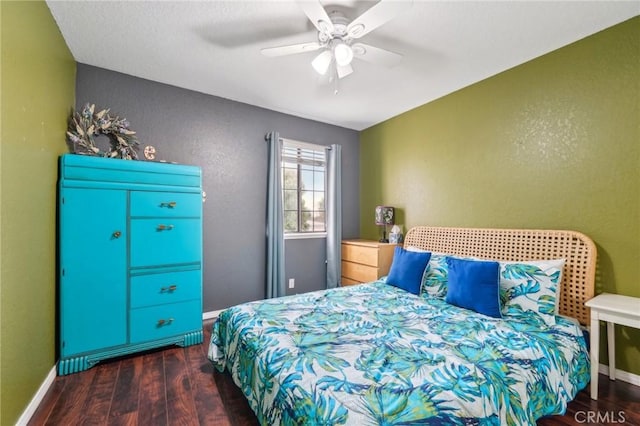 bedroom featuring a textured wall, ceiling fan, baseboards, and wood finished floors