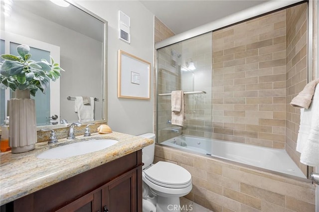 full bathroom with tiled shower / bath combo, visible vents, toilet, and vanity