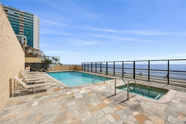 pool featuring a patio, a community hot tub, and a water view