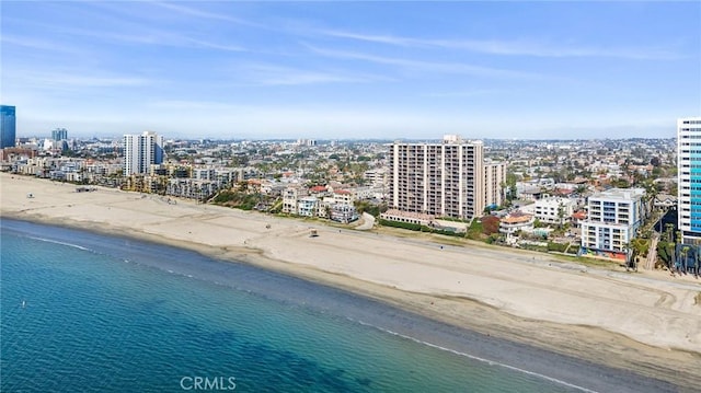 drone / aerial view featuring a view of city, a view of the beach, and a water view