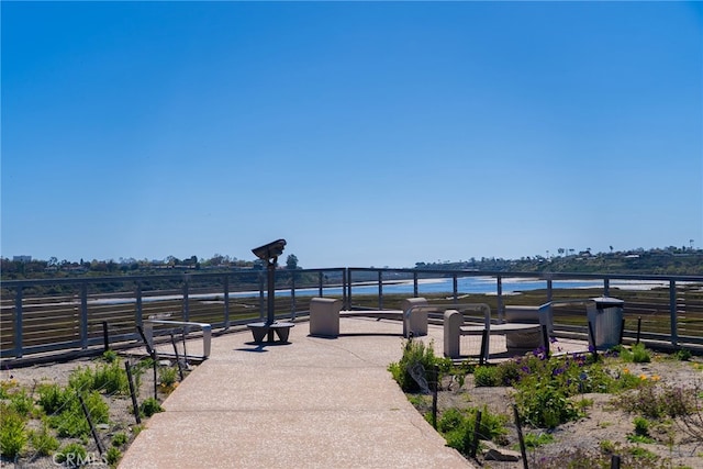 surrounding community with fence and a water view