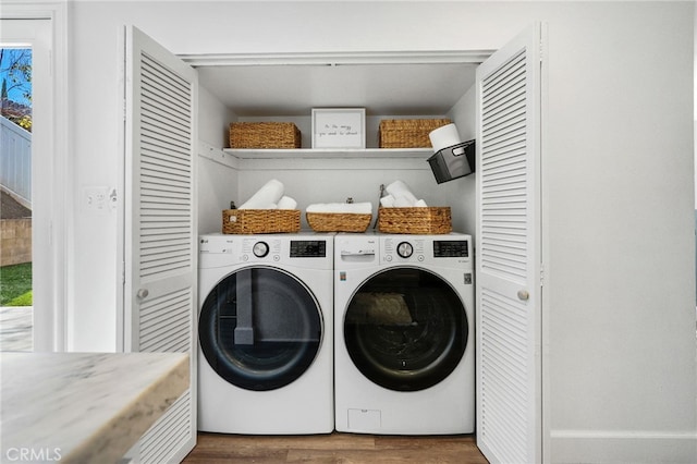 washroom with laundry area, wood finished floors, and washing machine and dryer