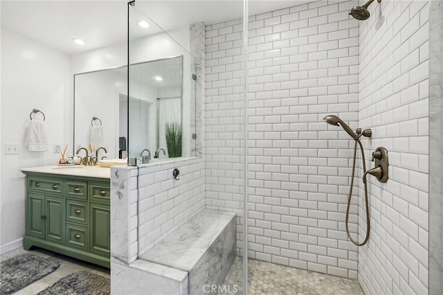 bathroom with vanity and a tile shower