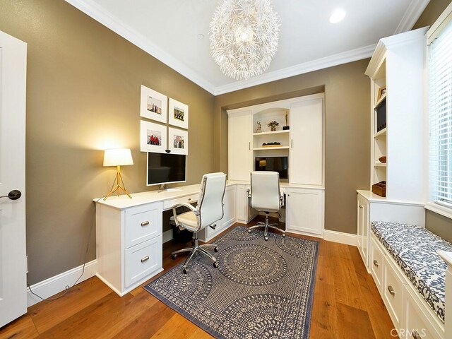 home office featuring crown molding, wood finished floors, built in desk, and baseboards