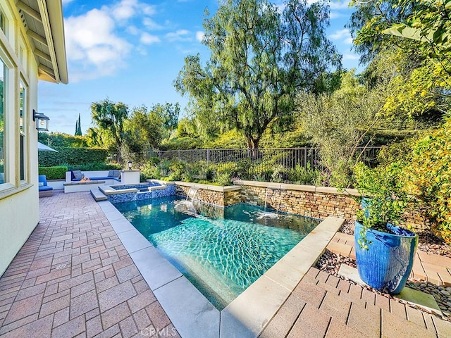 view of swimming pool featuring a patio, a fenced backyard, and a pool with connected hot tub