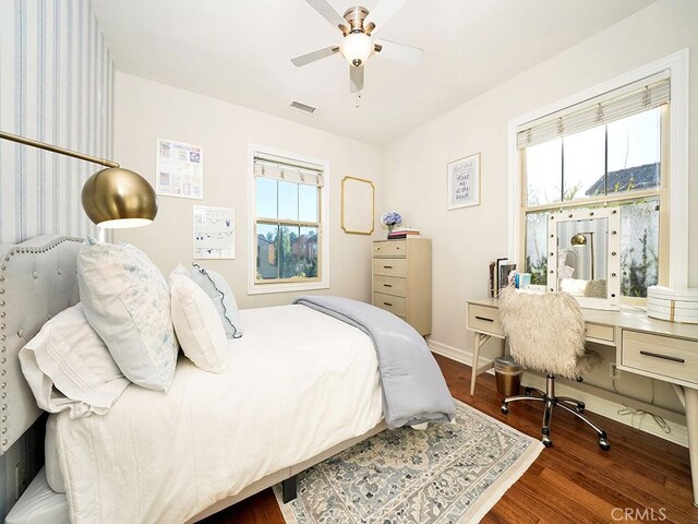 bedroom with multiple windows, wood finished floors, visible vents, and baseboards