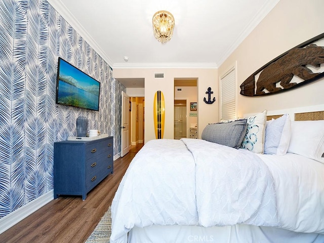 bedroom with visible vents, wood finished floors, crown molding, wallpapered walls, and an accent wall