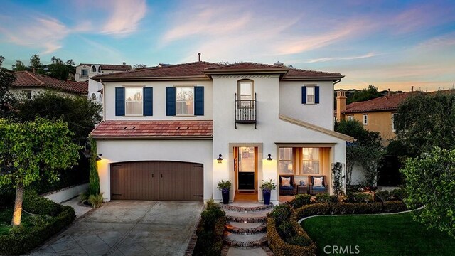 mediterranean / spanish-style home featuring stucco siding, a garage, and concrete driveway