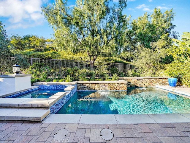 view of pool featuring a pool with connected hot tub and fence