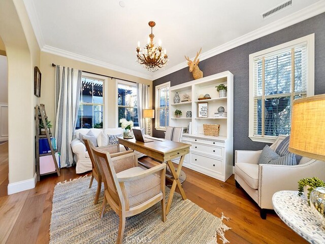 dining space with a chandelier, visible vents, light wood-style flooring, and ornamental molding