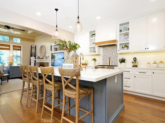 kitchen with tasteful backsplash, light wood-style flooring, and white cabinets