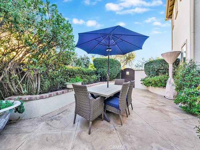 view of patio with outdoor dining space and a gate