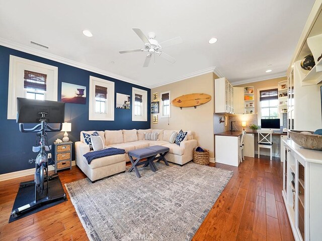 living room with visible vents, a ceiling fan, wood-type flooring, crown molding, and baseboards