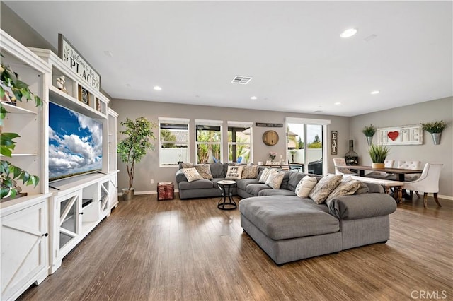 living room featuring visible vents, plenty of natural light, and wood finished floors