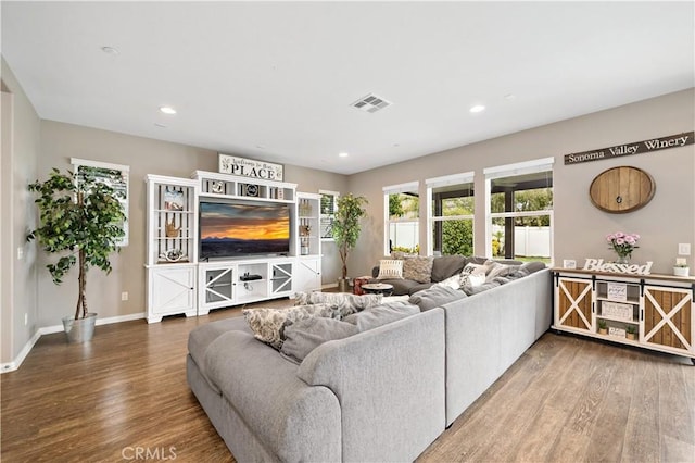 living room with visible vents, recessed lighting, baseboards, and wood finished floors