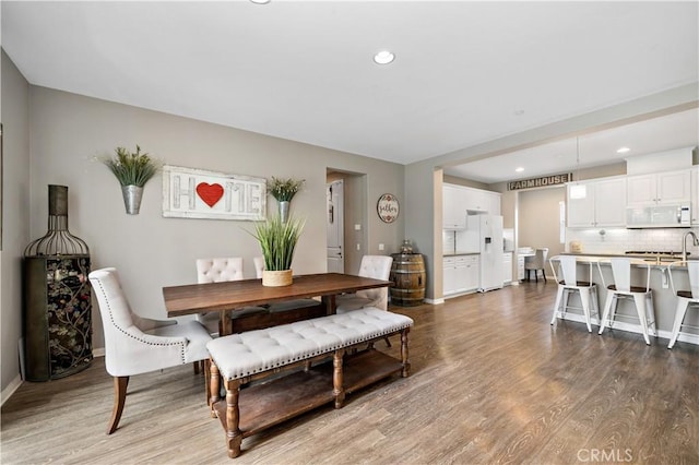 dining space with recessed lighting, baseboards, and wood finished floors