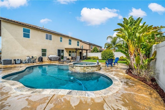 view of swimming pool featuring central AC unit, a pool with connected hot tub, a patio area, and a fenced backyard