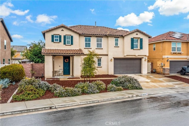 mediterranean / spanish home featuring stucco siding, a garage, concrete driveway, and a tile roof