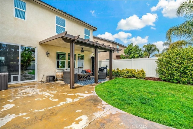 rear view of house featuring fence, stucco siding, a yard, a patio area, and a ceiling fan