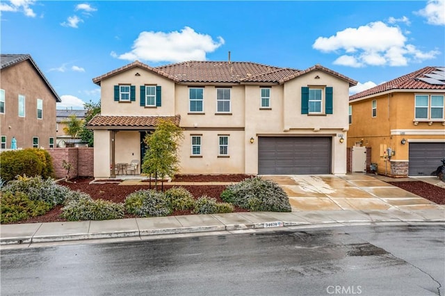 mediterranean / spanish home featuring fence, an attached garage, stucco siding, concrete driveway, and a tiled roof