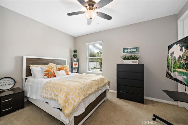 bedroom featuring baseboards, light colored carpet, and ceiling fan