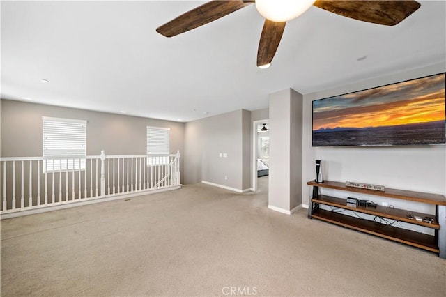 unfurnished living room featuring baseboards, carpet, and ceiling fan