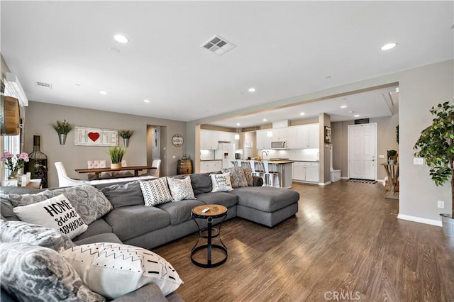 living room featuring visible vents, recessed lighting, and dark wood-style flooring