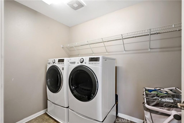 washroom featuring washing machine and clothes dryer, laundry area, and baseboards